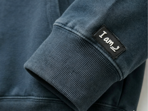 Dark blue sweatshirt with a patch on the sleeve displaying "I am".