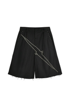 Black wide-leg shorts with diagonal rows of silver studs and frayed raw hems